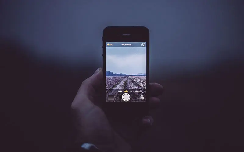 A person taking a picture of an empty road on their phone.