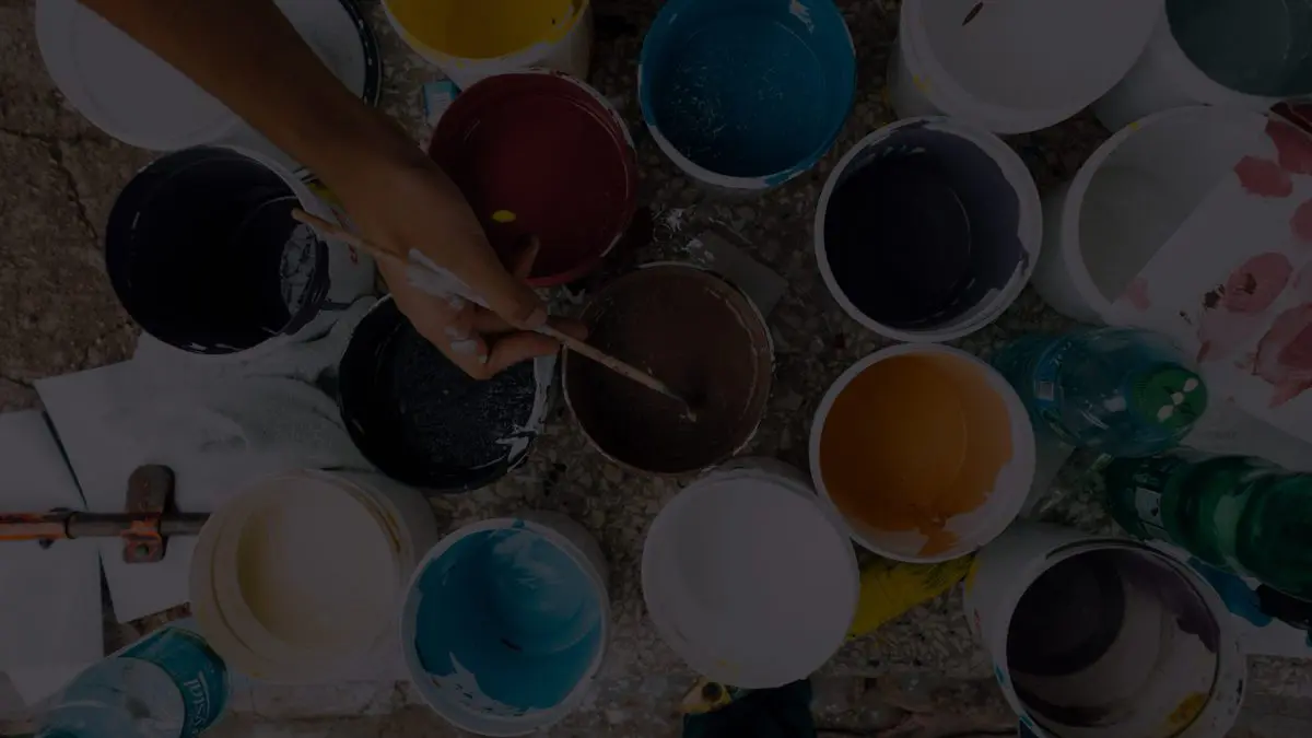 A person painting some different colors of paint.